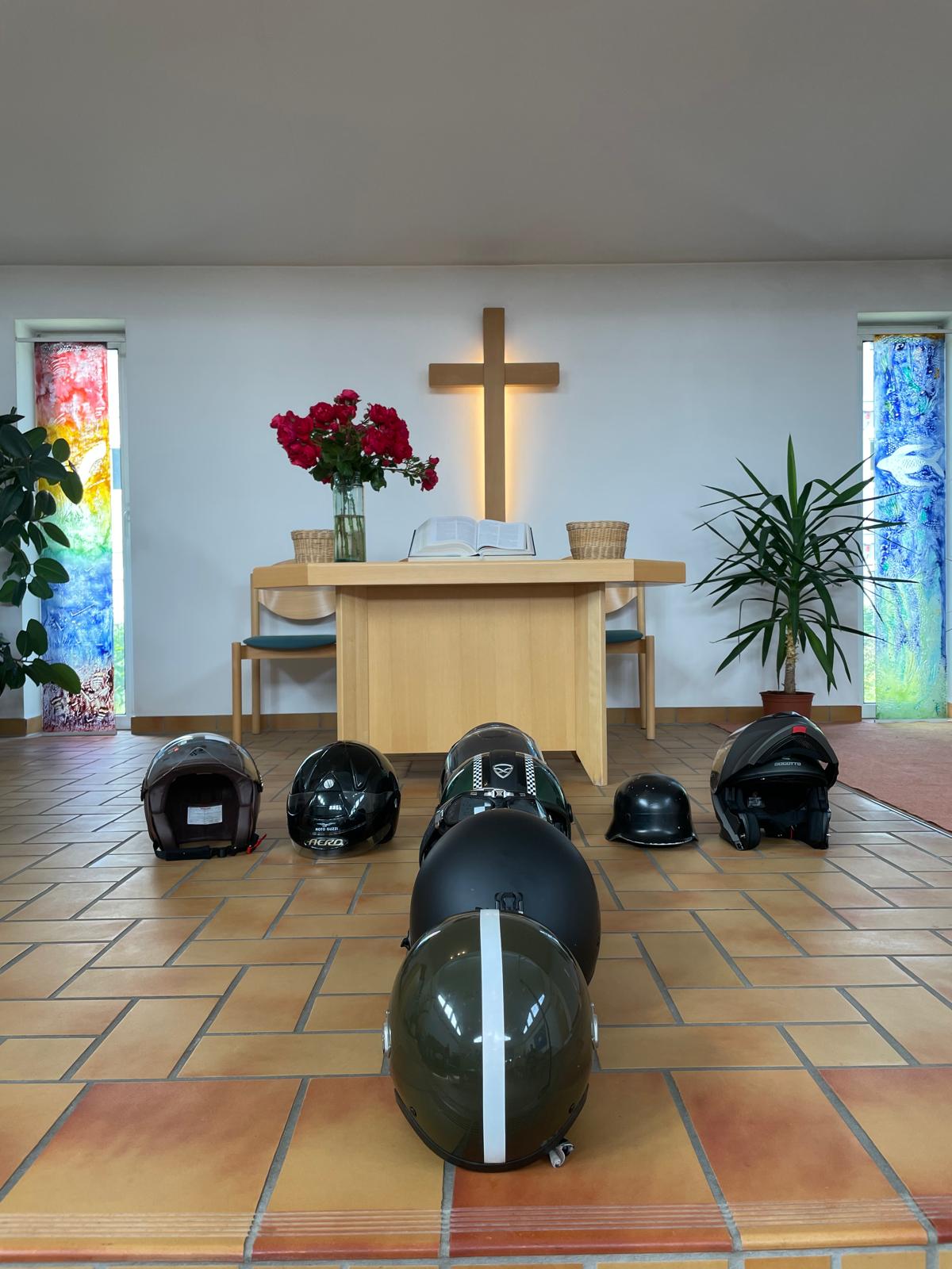 Motorradhelme vor dem Kreuz